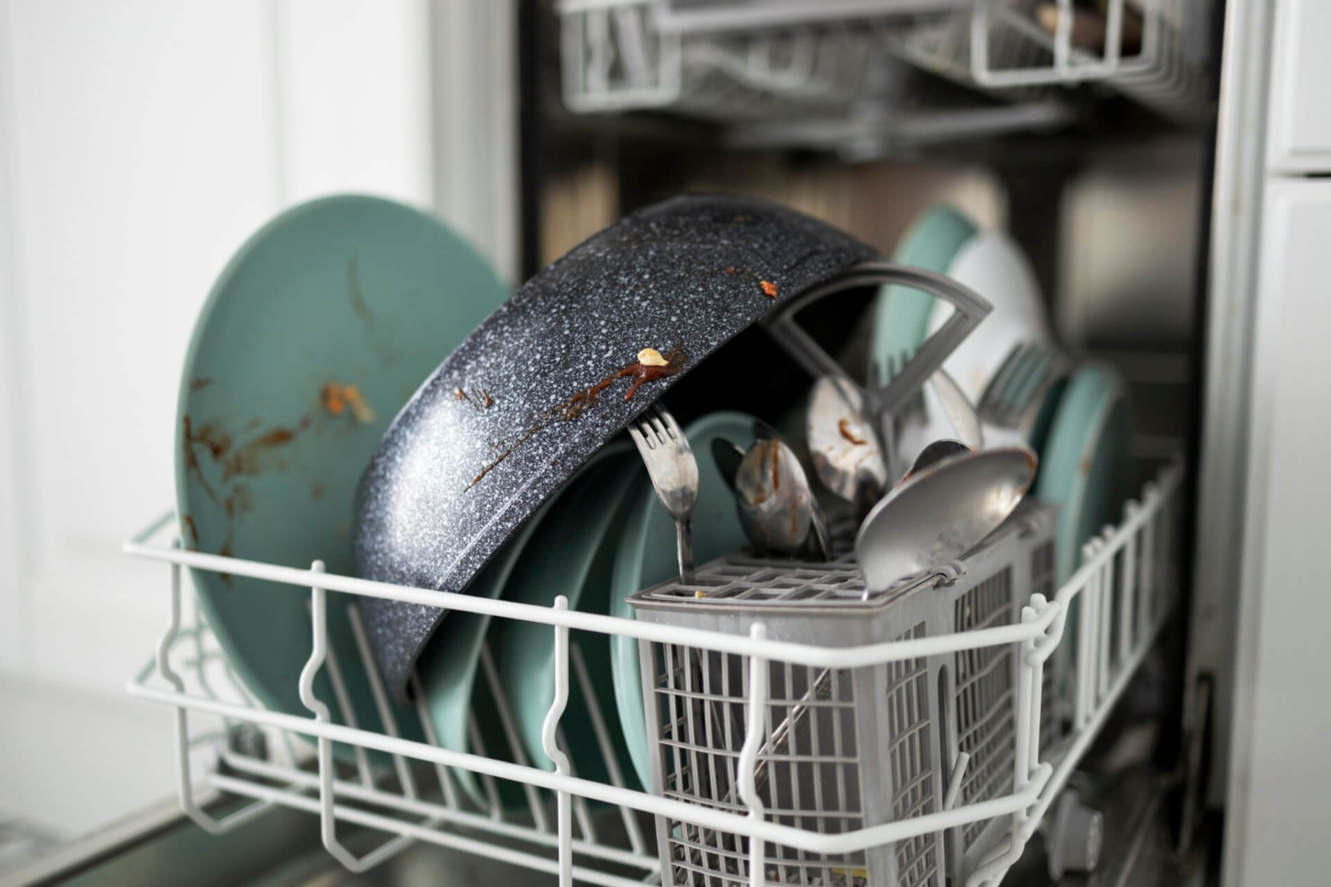 Open dishwasher with closed soap dispenser still containing detergent - a common problem in Australian households